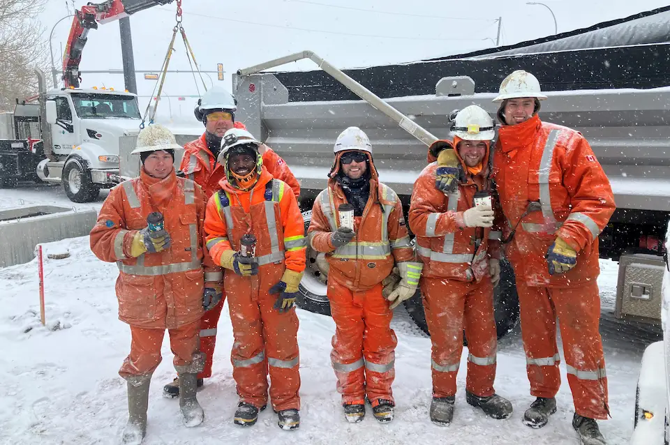 An image showing a safety manager working with employees on a worksite.