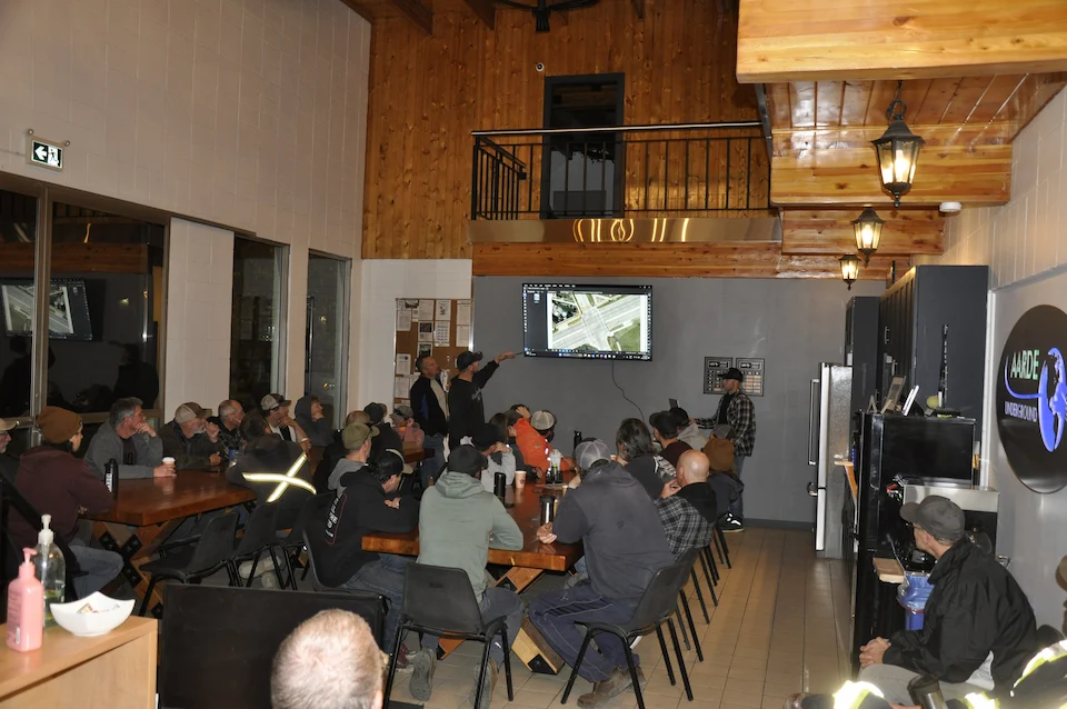 Two large tables full of employees attending a safety presentation.