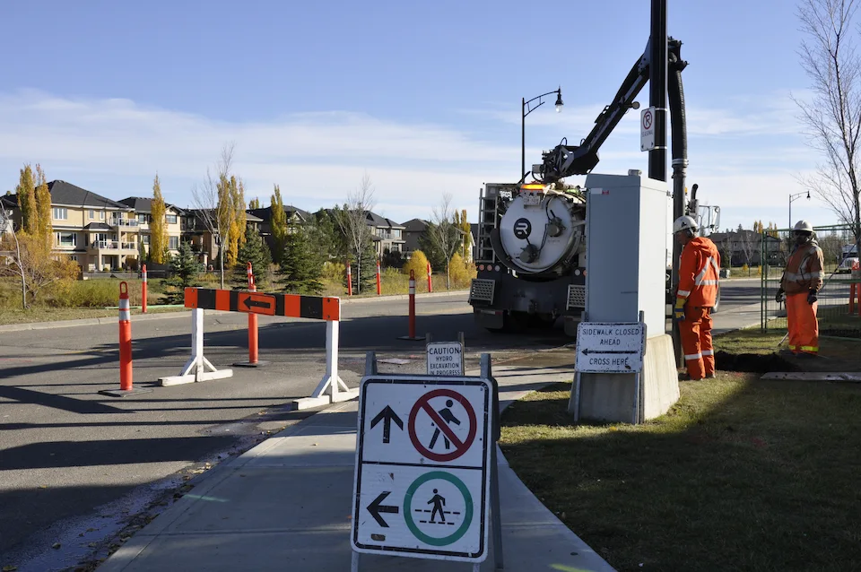 A team working in a community with a number of safety barricades and signs.