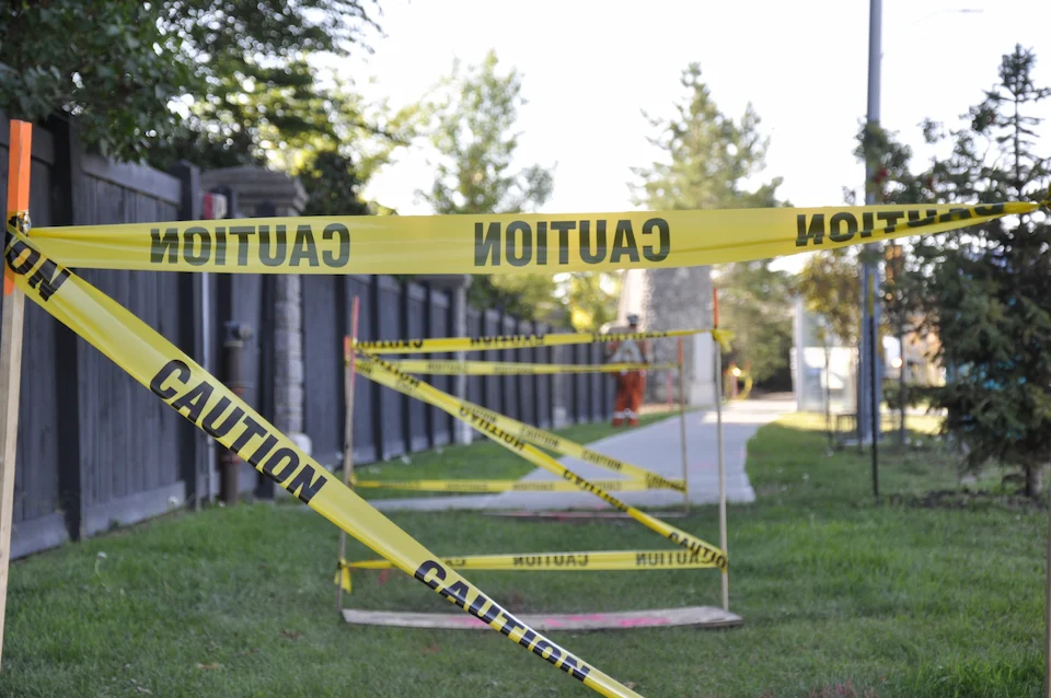 Barricades around open holes with caution tape to create a safe work area.