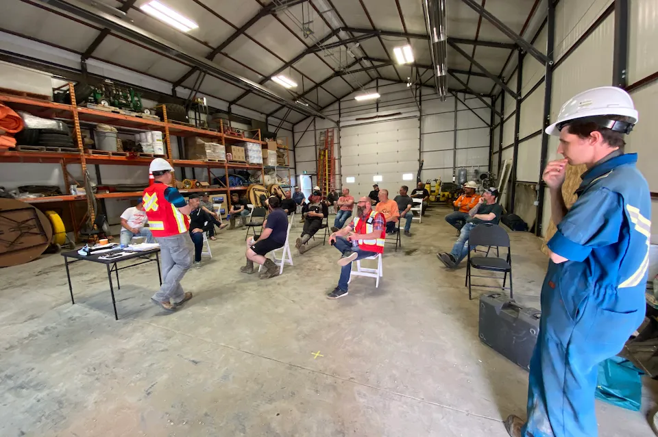 A crowd of employees participating in a safety training meeting.